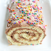 Vanilla Roll Cake with Chocolate Frosting #rollcake #vanillacake #dessert #chocolate #frosting #chocolatefrosting #tableforsevenblog