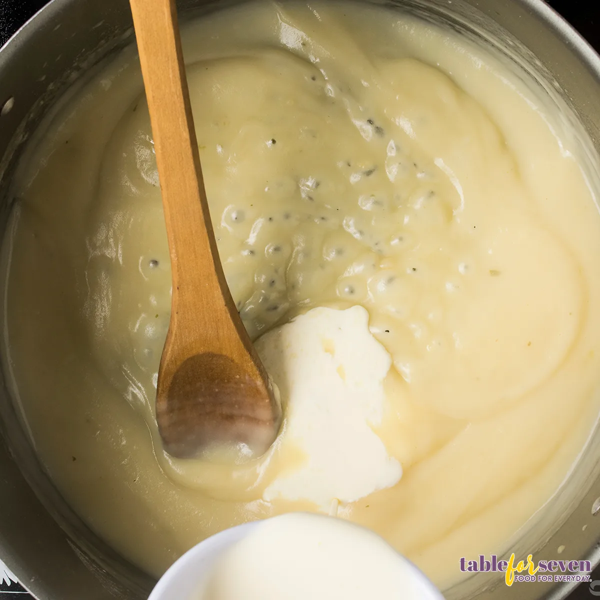 Heavy cream being stirred into a smooth sauce for turkey tetrazzini.