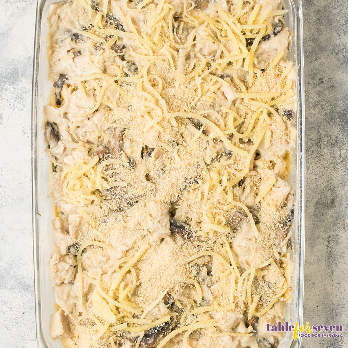 Grated parmesan cheese sprinkled over the casserole, ready for baking.