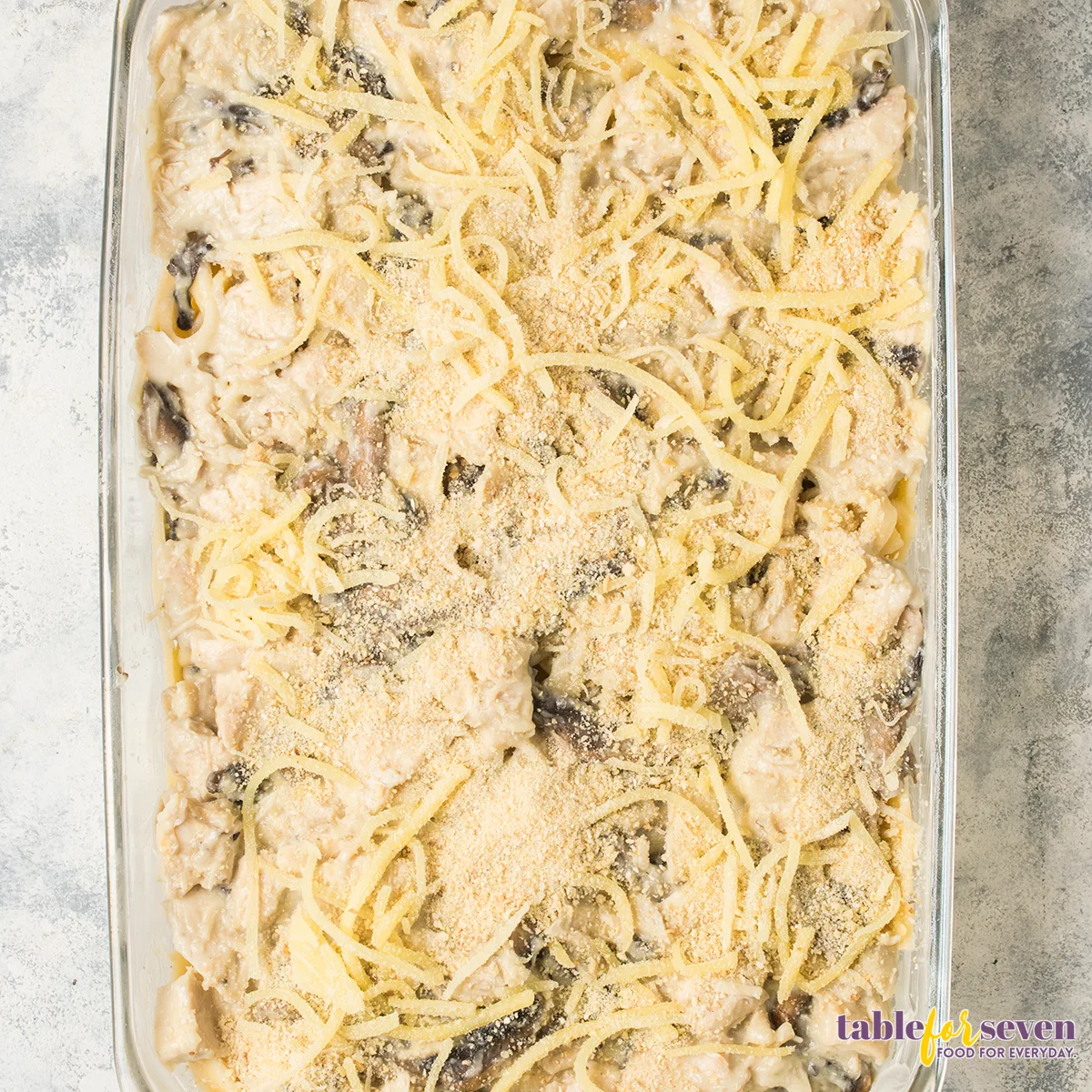 Grated parmesan cheese sprinkled over the casserole, ready for baking.