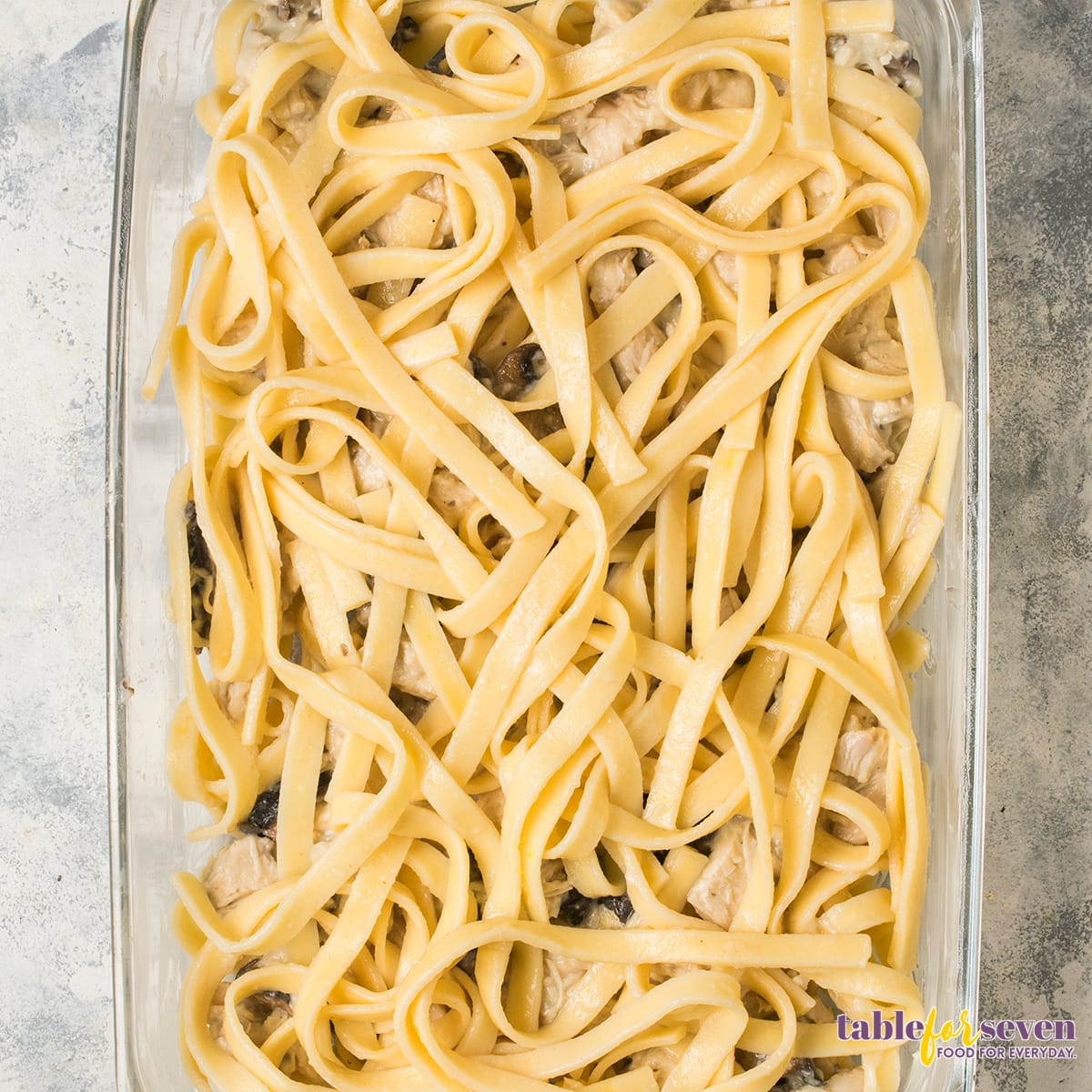 Cooked pasta layered into the baking dish as the base for turkey tetrazzini.