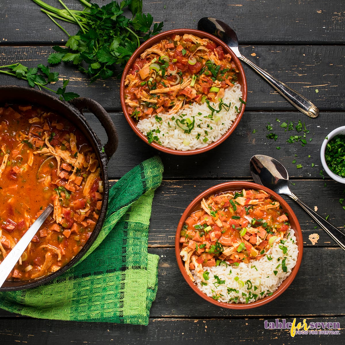 Top view of chicken and sausage gumbo bowl with rice and garnish