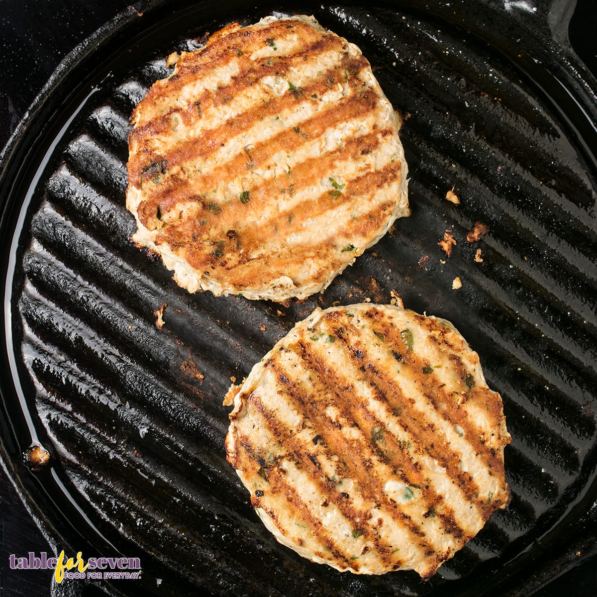 Grilled turkey burger patties on a cast iron pan