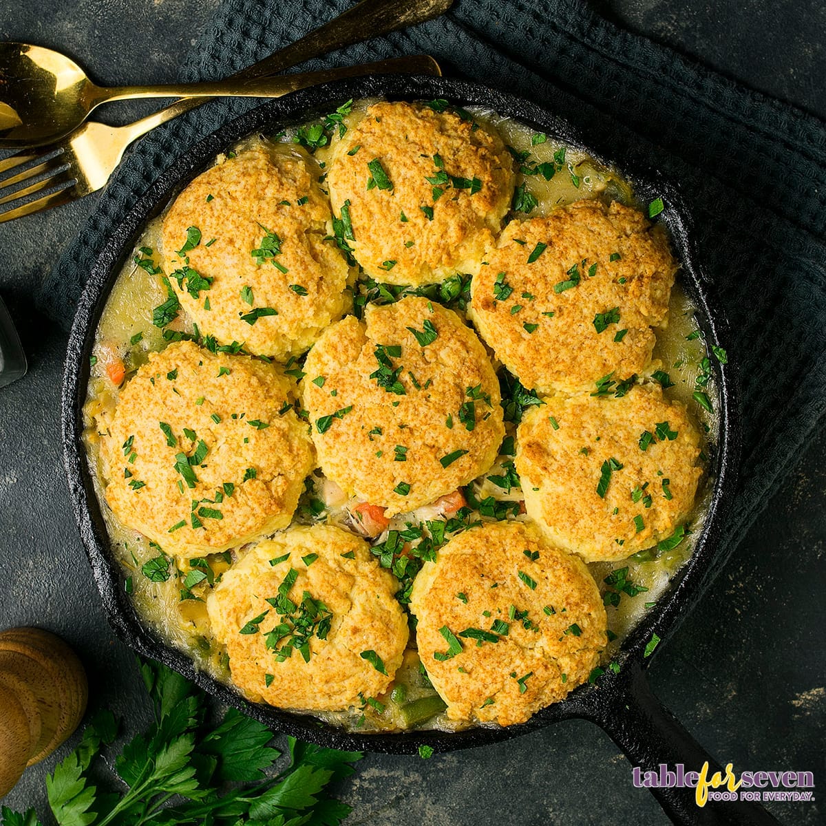 Top view of chicken pot pie with golden biscuits garnished with parsley