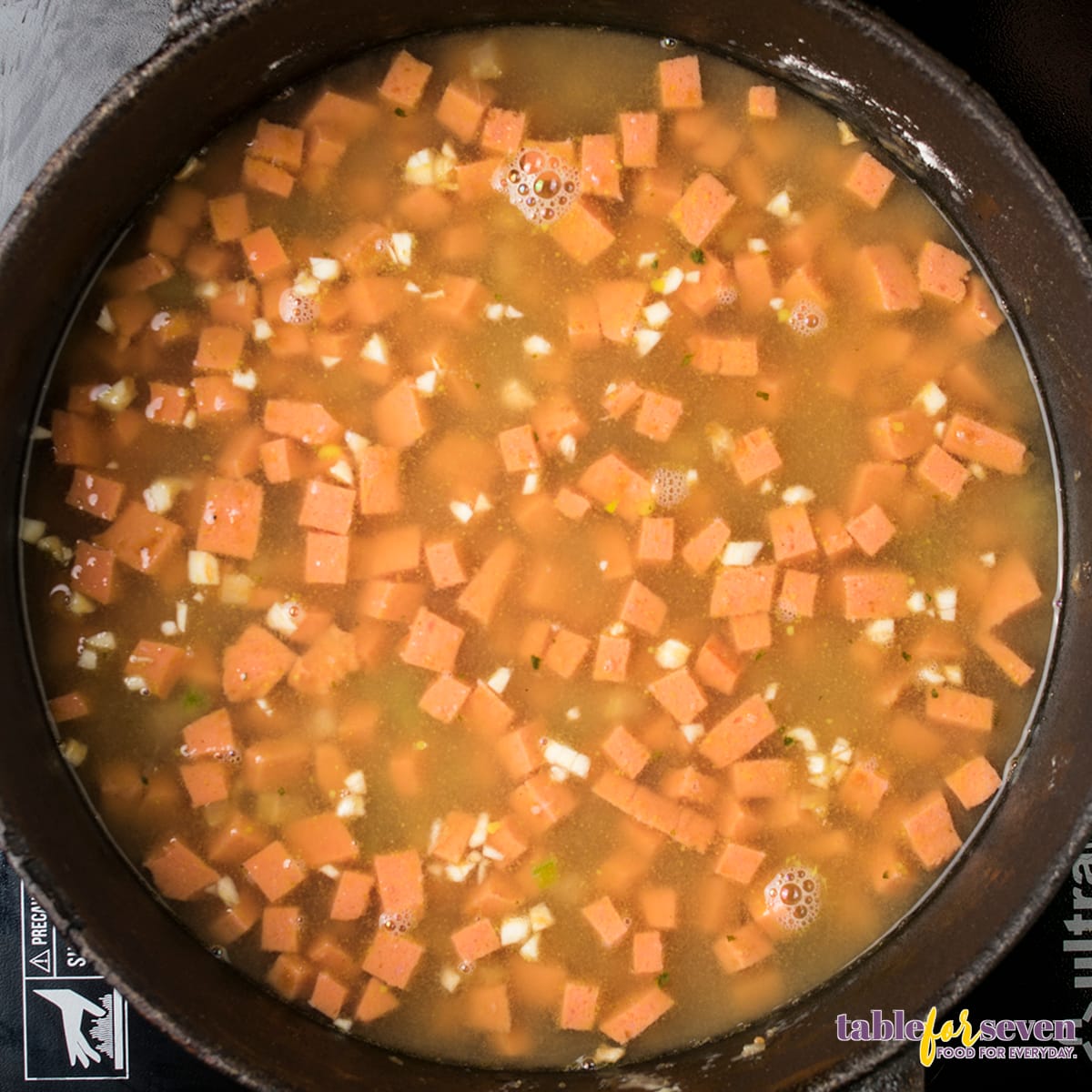 Sausage pieces simmering in stock for gumbo