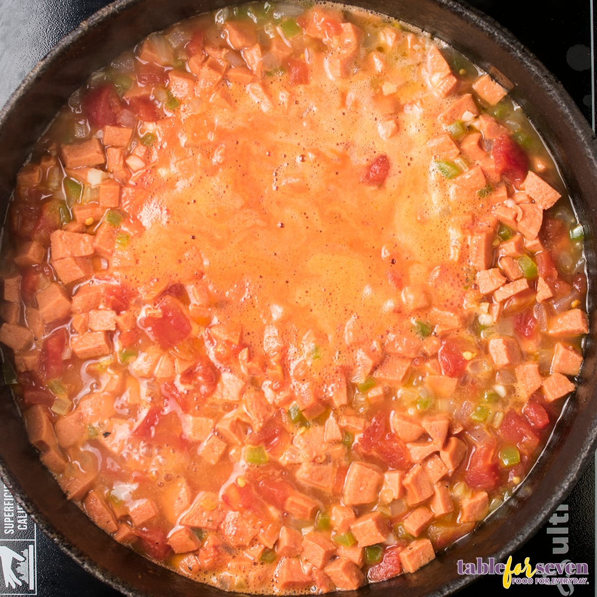 Tomato and sausage gumbo mixture boiling