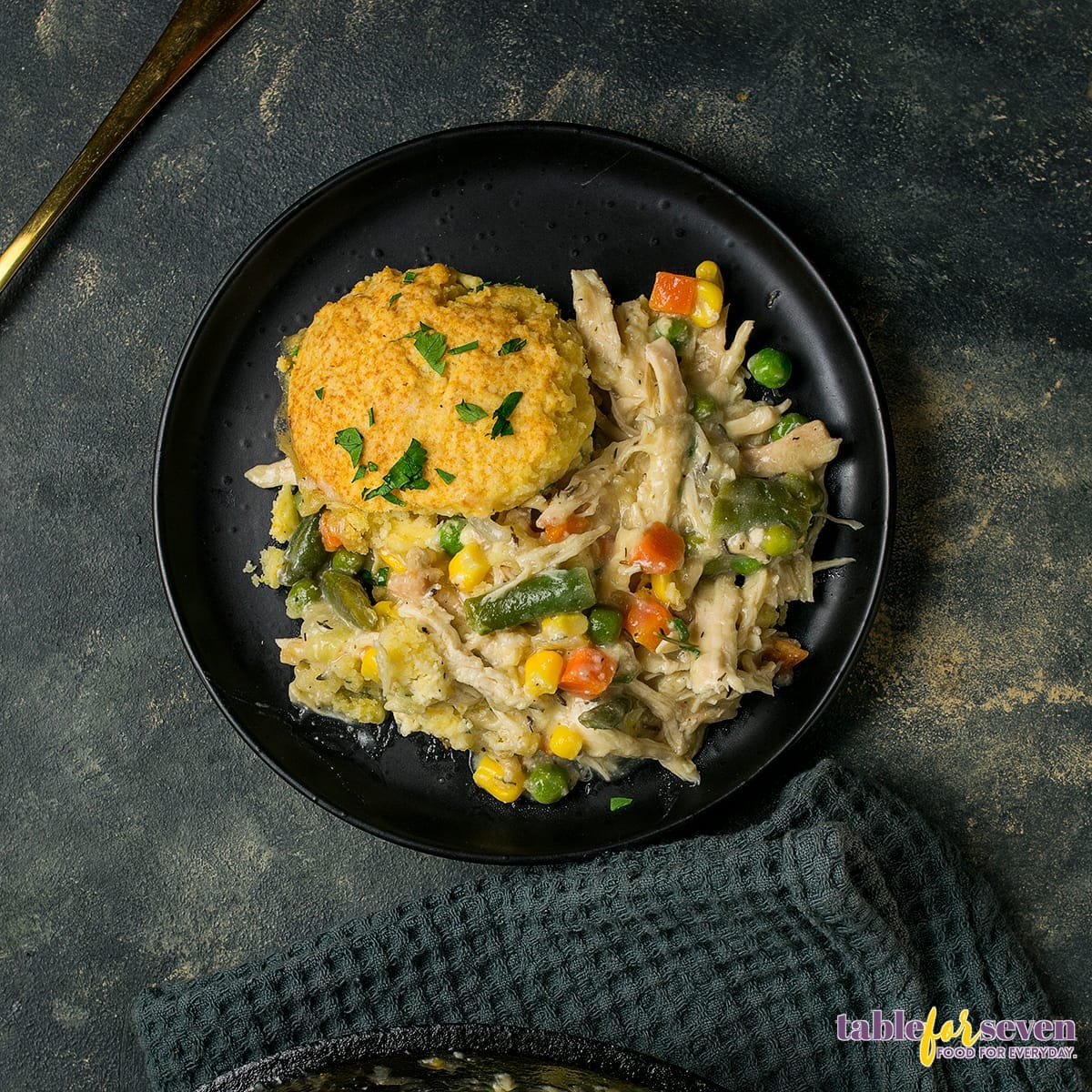 Top view of a plate with chicken pot pie and a biscuit