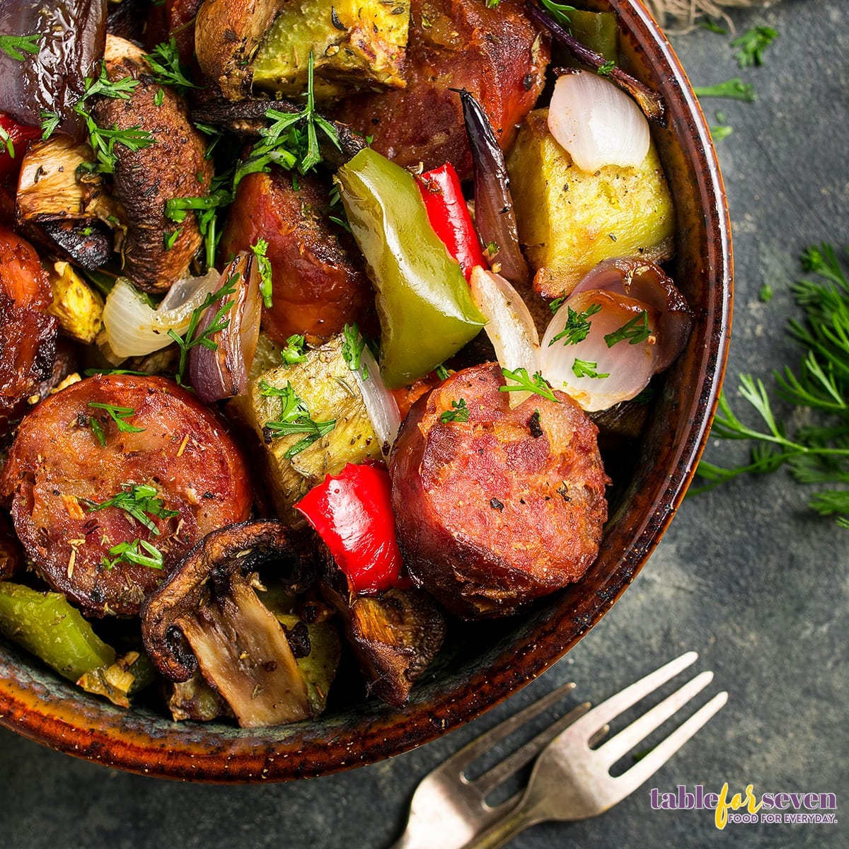 Close-up of sausage and roasted vegetables with fresh herbs