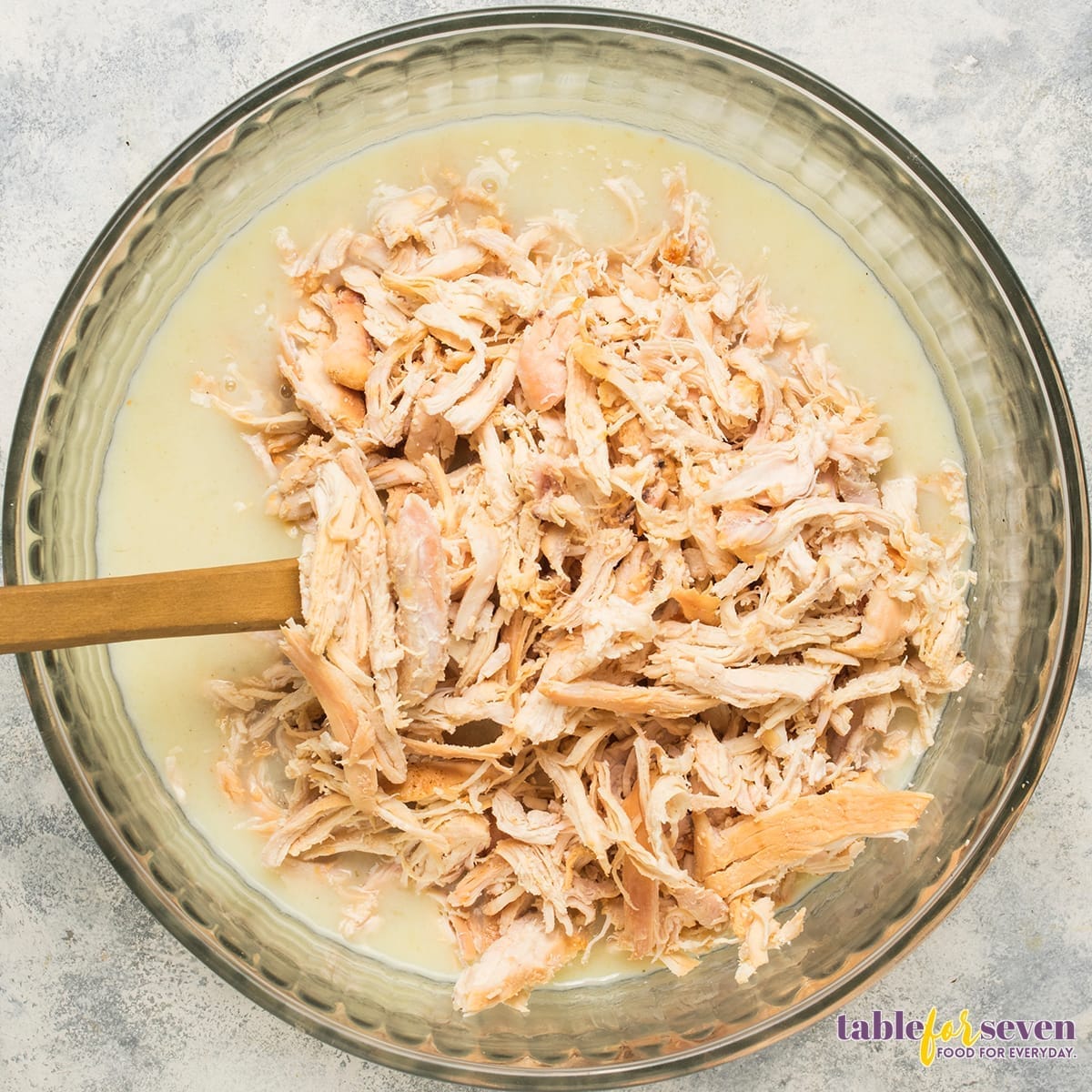 Adding shredded chicken to the creamy mixture for Pioneer Woman Chicken and Dressing Casserole