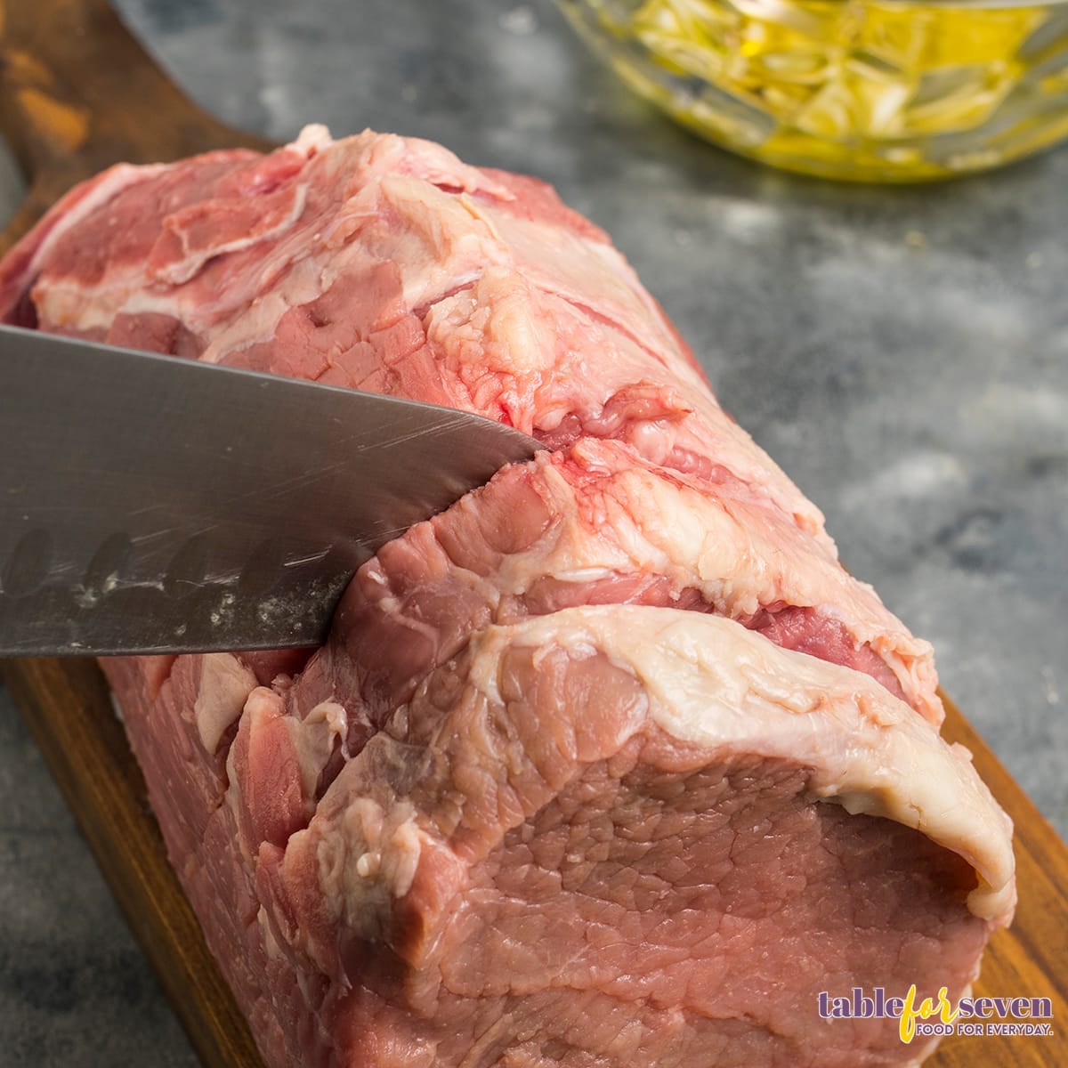 cutting the raw rump roast before cooking