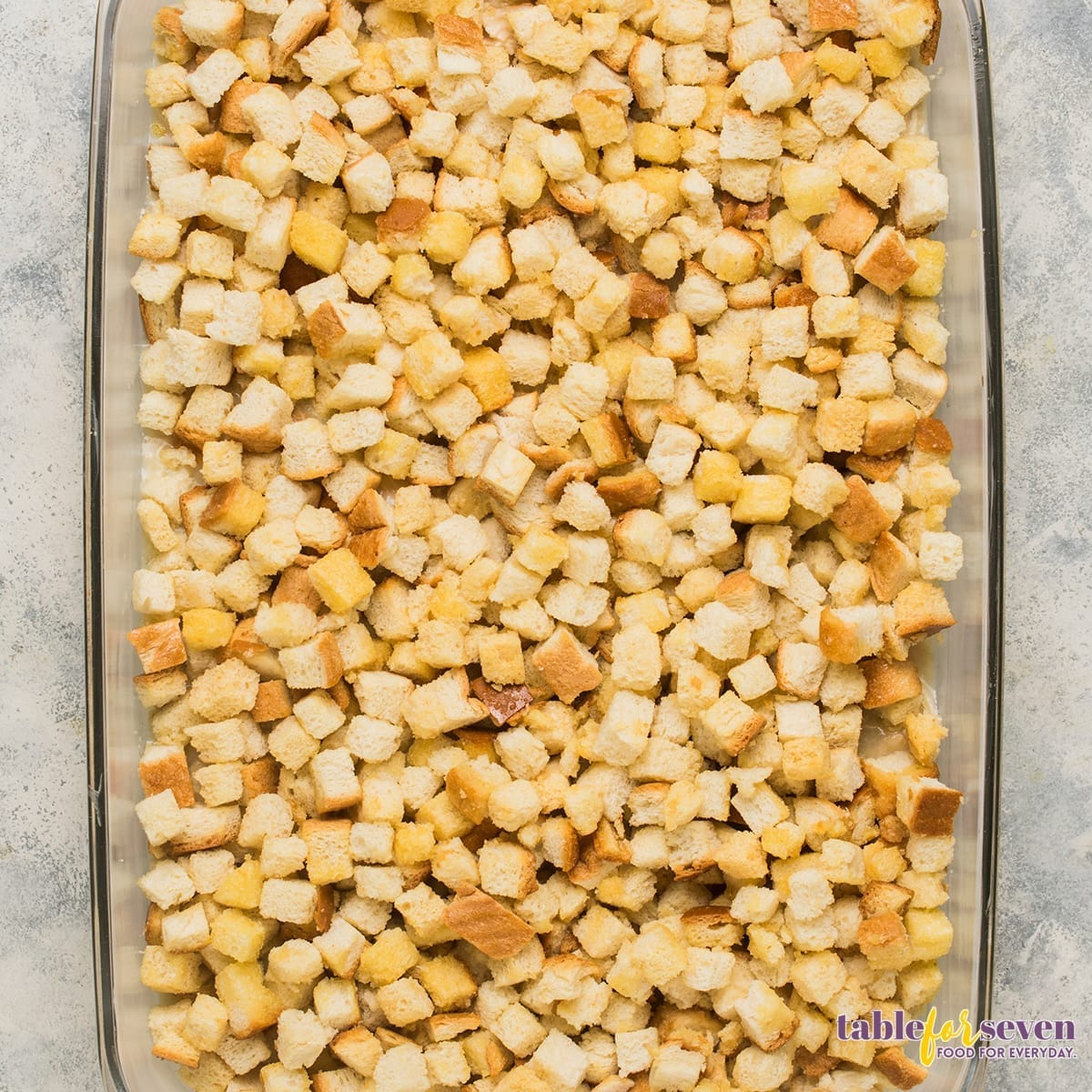 Dry bread stuffing mix spread in a baking dish for Pioneer Woman Chicken and Dressing Casserole