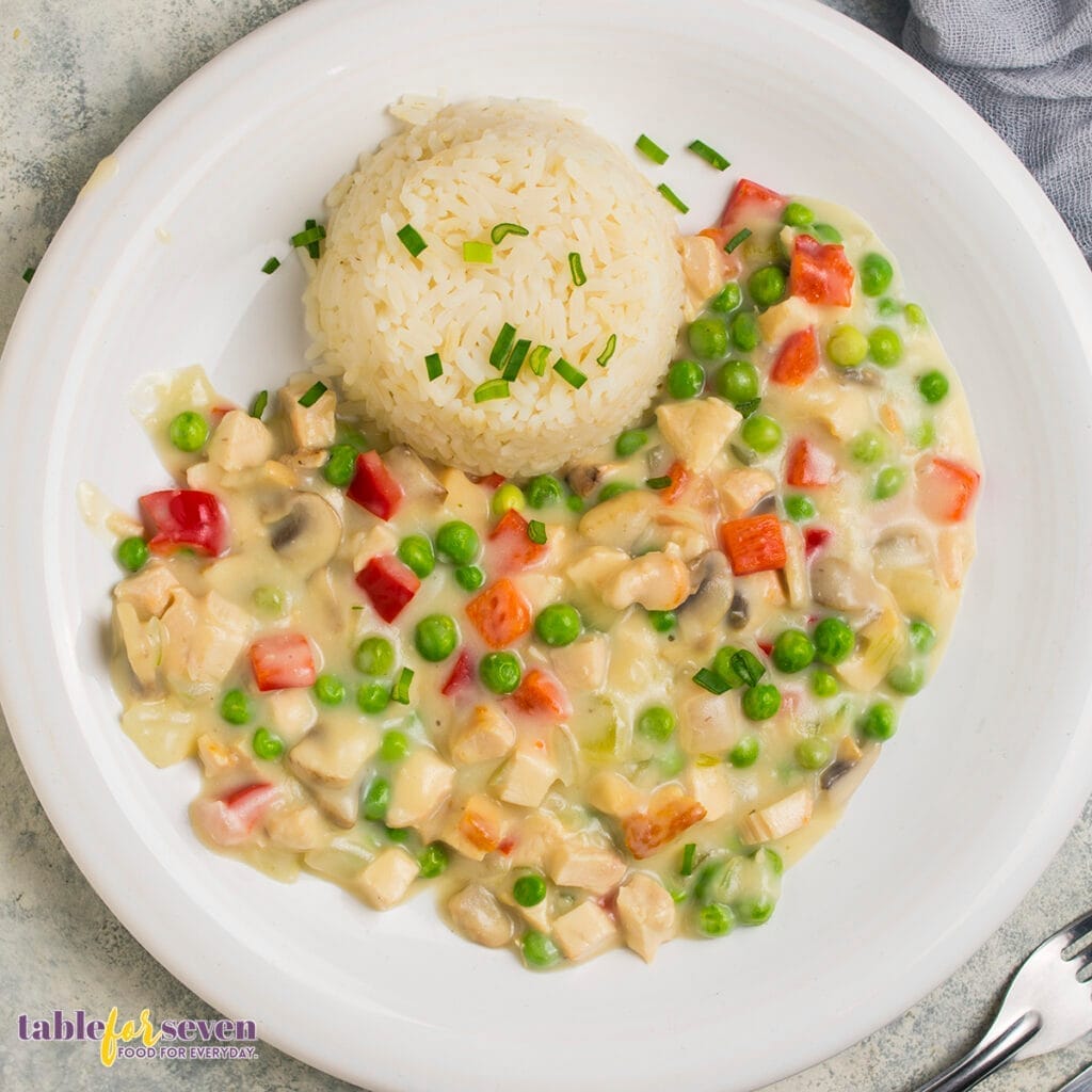 Chicken Ala King served with rice on a plate, top view