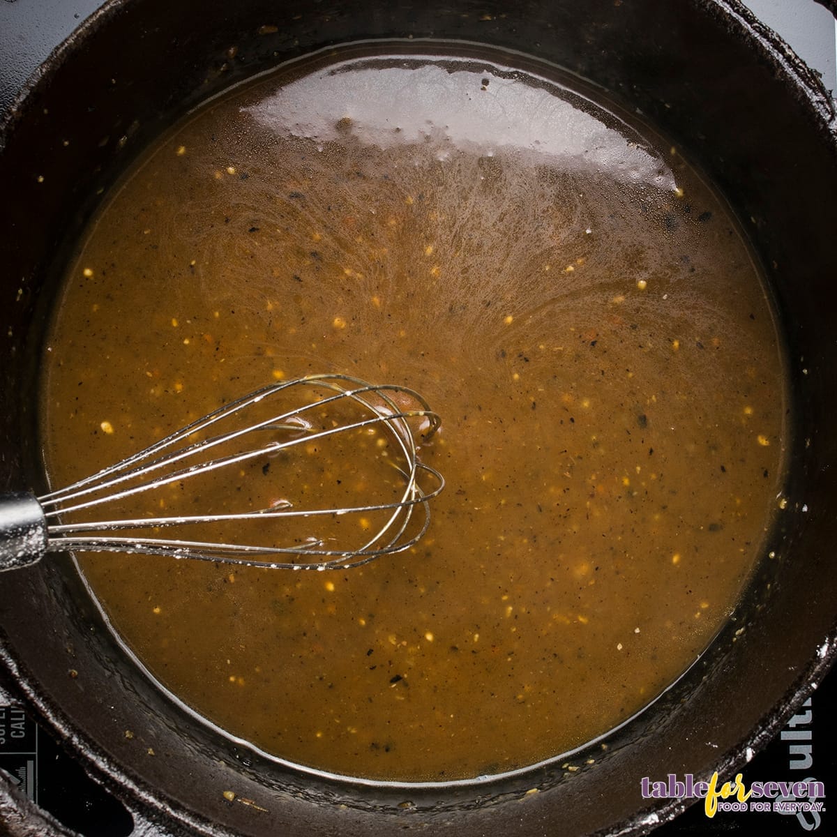 Whisking gravy sauce in the Dutch oven after roasting