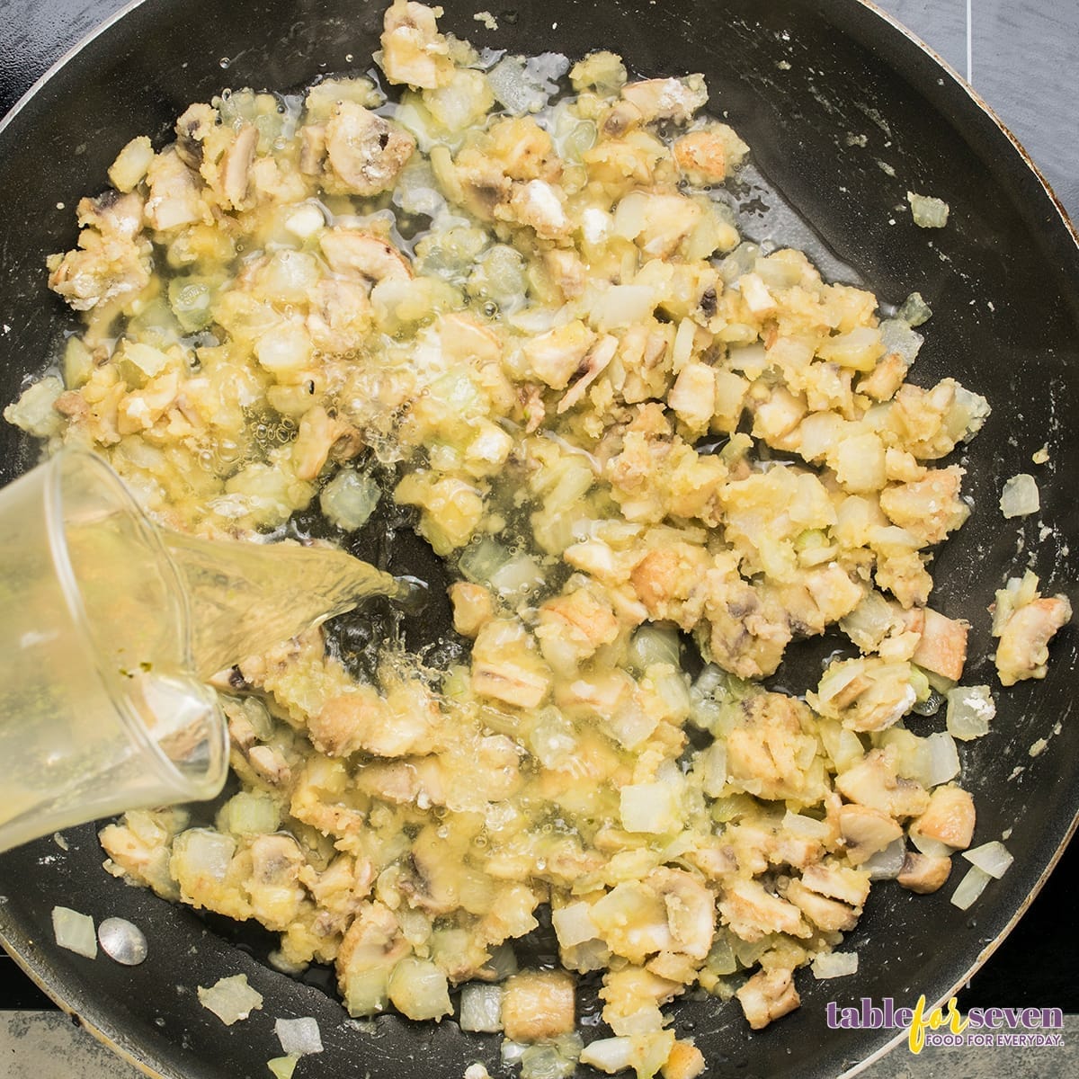 Pouring chicken broth into the mushroom and onion mixture for Chicken Ala King