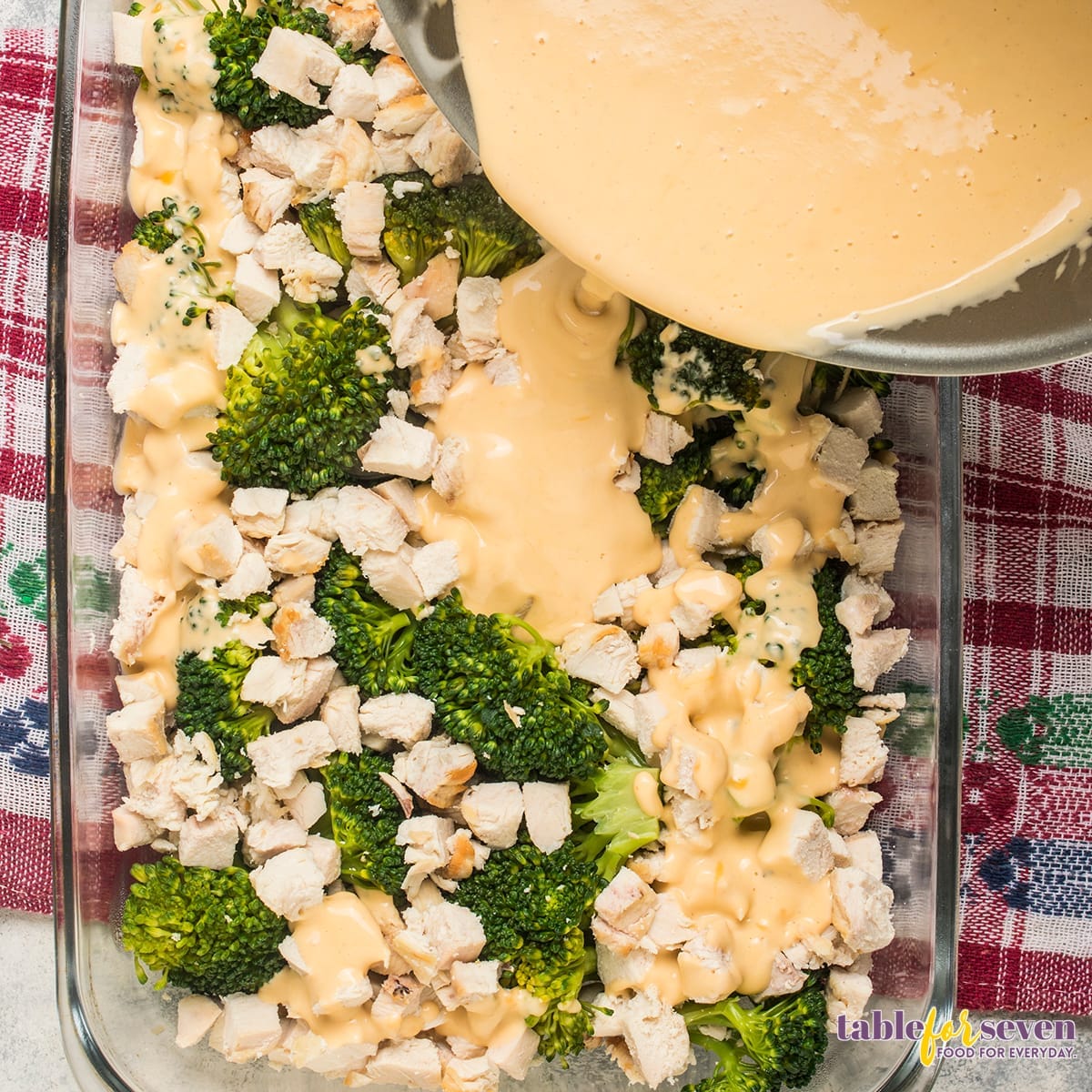 Pouring cheese sauce over the chicken and broccoli mixture