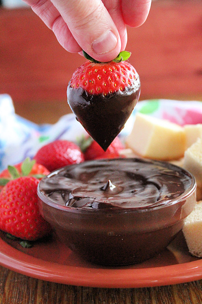 dipping strawberry in Crock Pot Chocolate Fondue