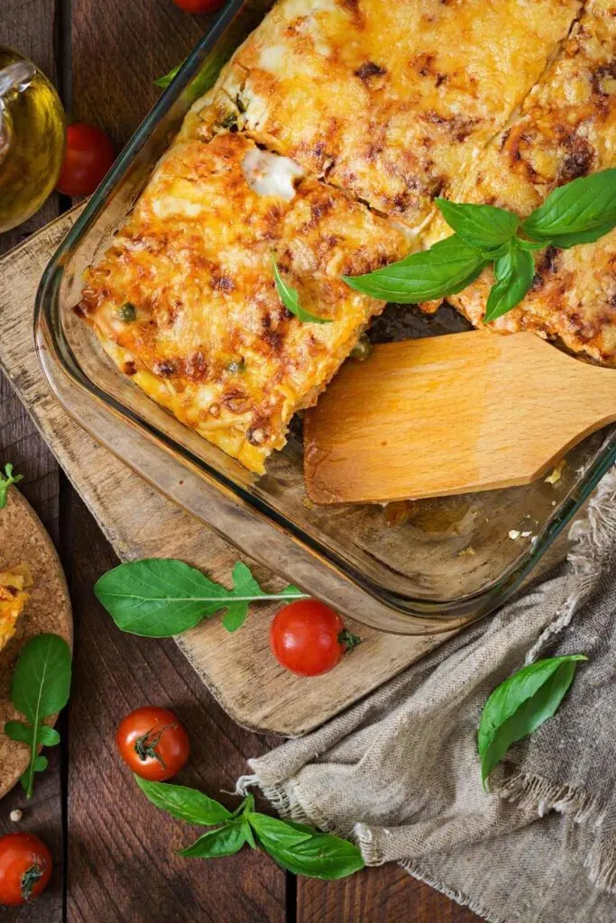 Premium Photo  Woman holding spatula with piece of spinach lasagna over  baking dish