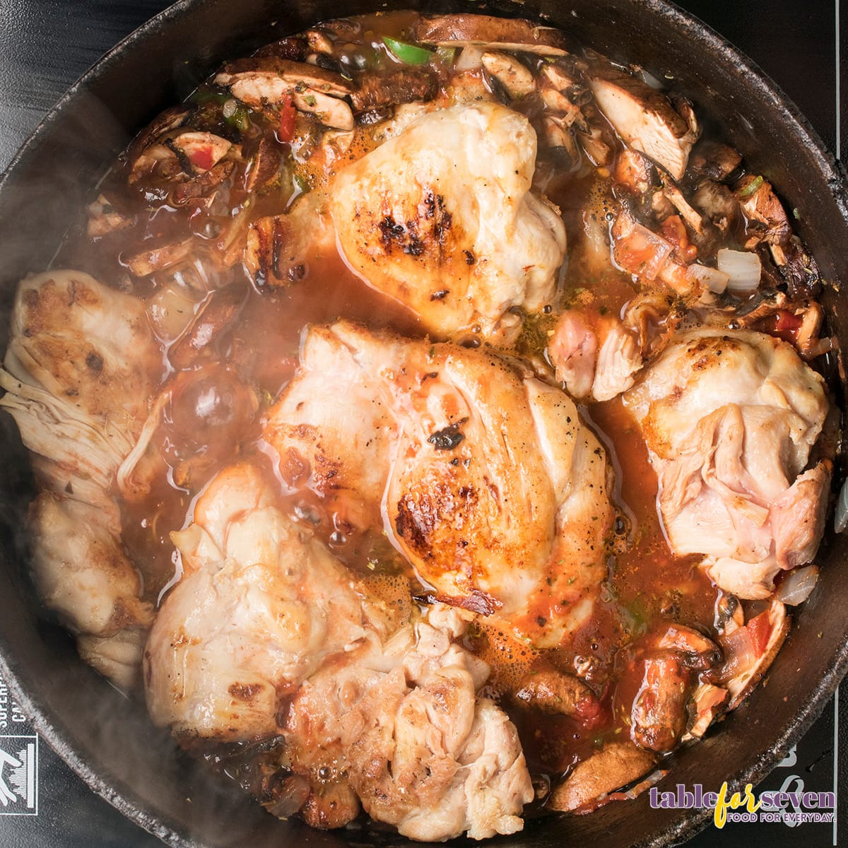 Golden seared chicken thighs ready for slow cooking in Chicken Cacciatore sauce