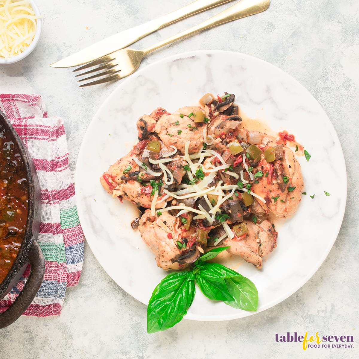 Top view of Chicken Cacciatore plated with fresh basil and melted cheese