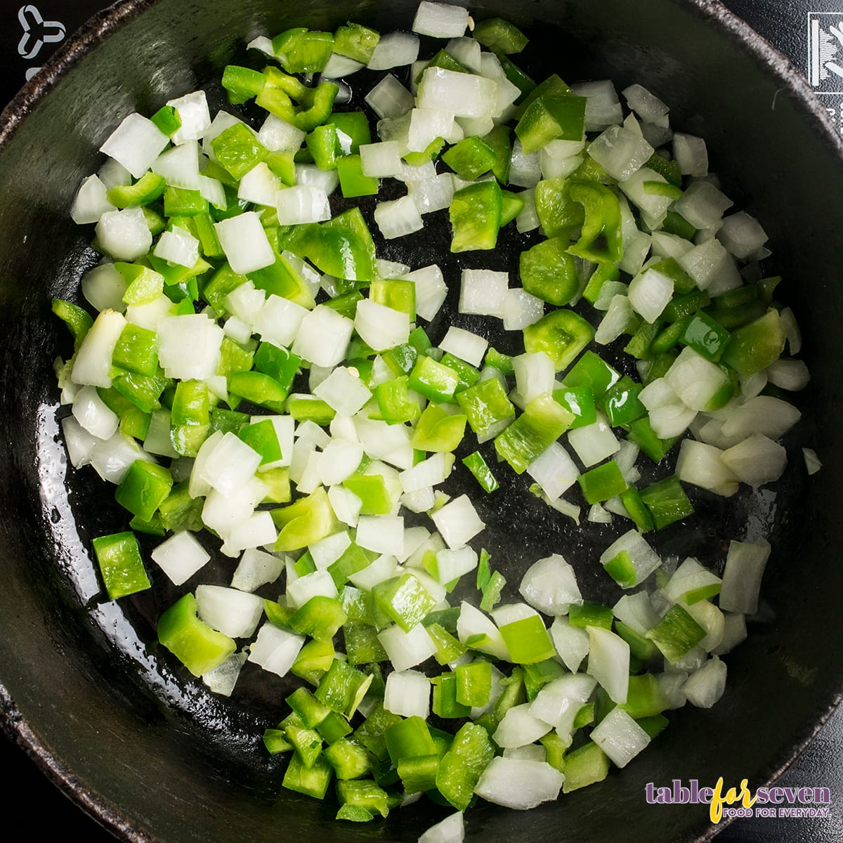 Green bell peppers and onions sautéing in a skillet for Chicken Cacciatore