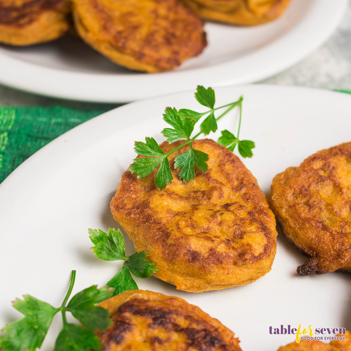 Close-up of sweet potato jacks garnished with parsley on a white plate