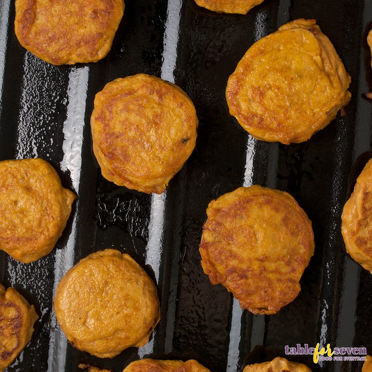 Sweet potato jacks baking on a dark non-stick pan