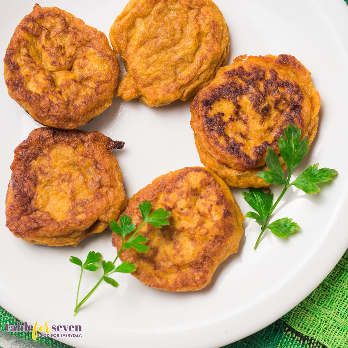 Top view of sweet potato jacks garnished with fresh parsley on a white plate