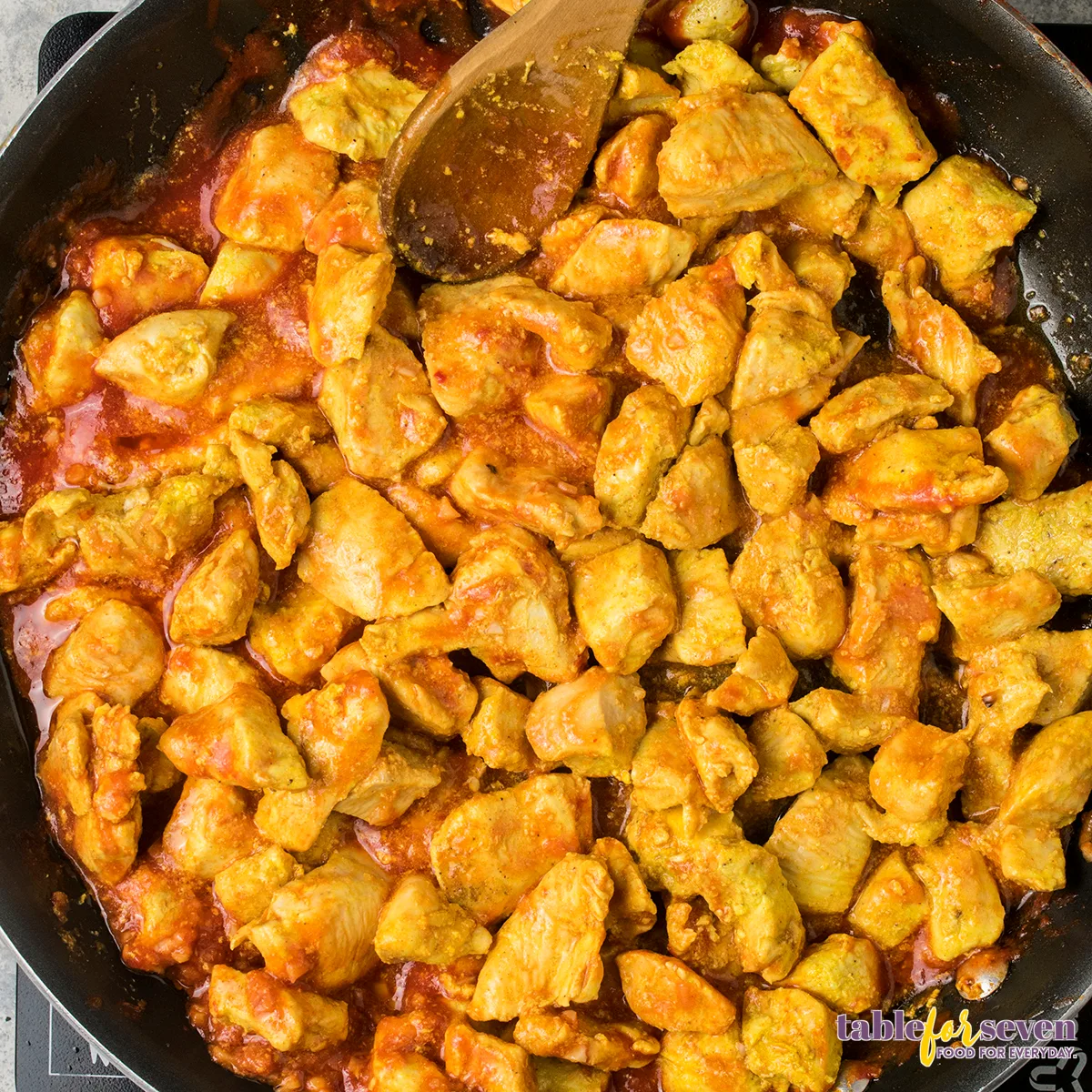 Chicken simmering in butter chicken sauce