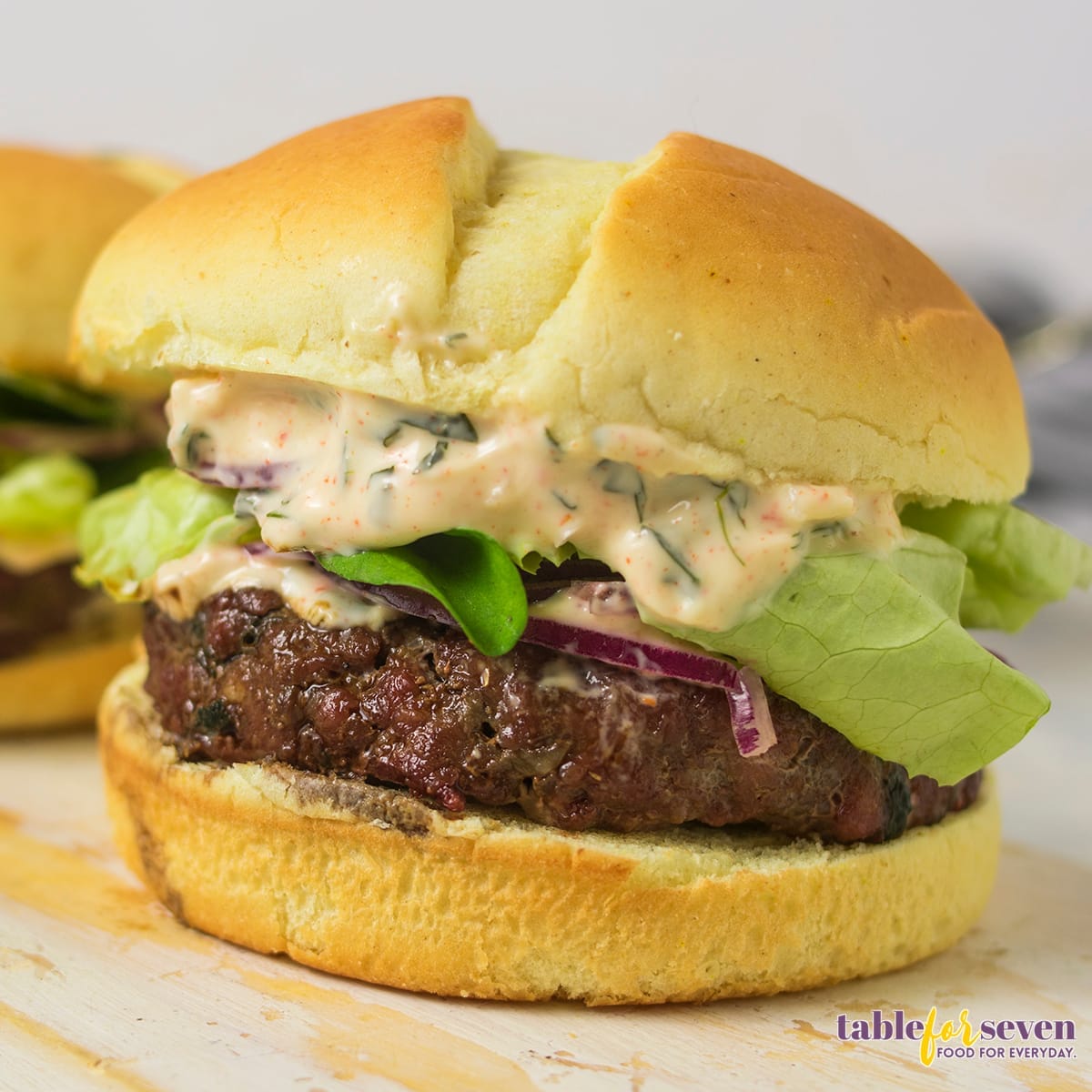 Lamb Burger served on a bun with sauce, lettuce, and onion