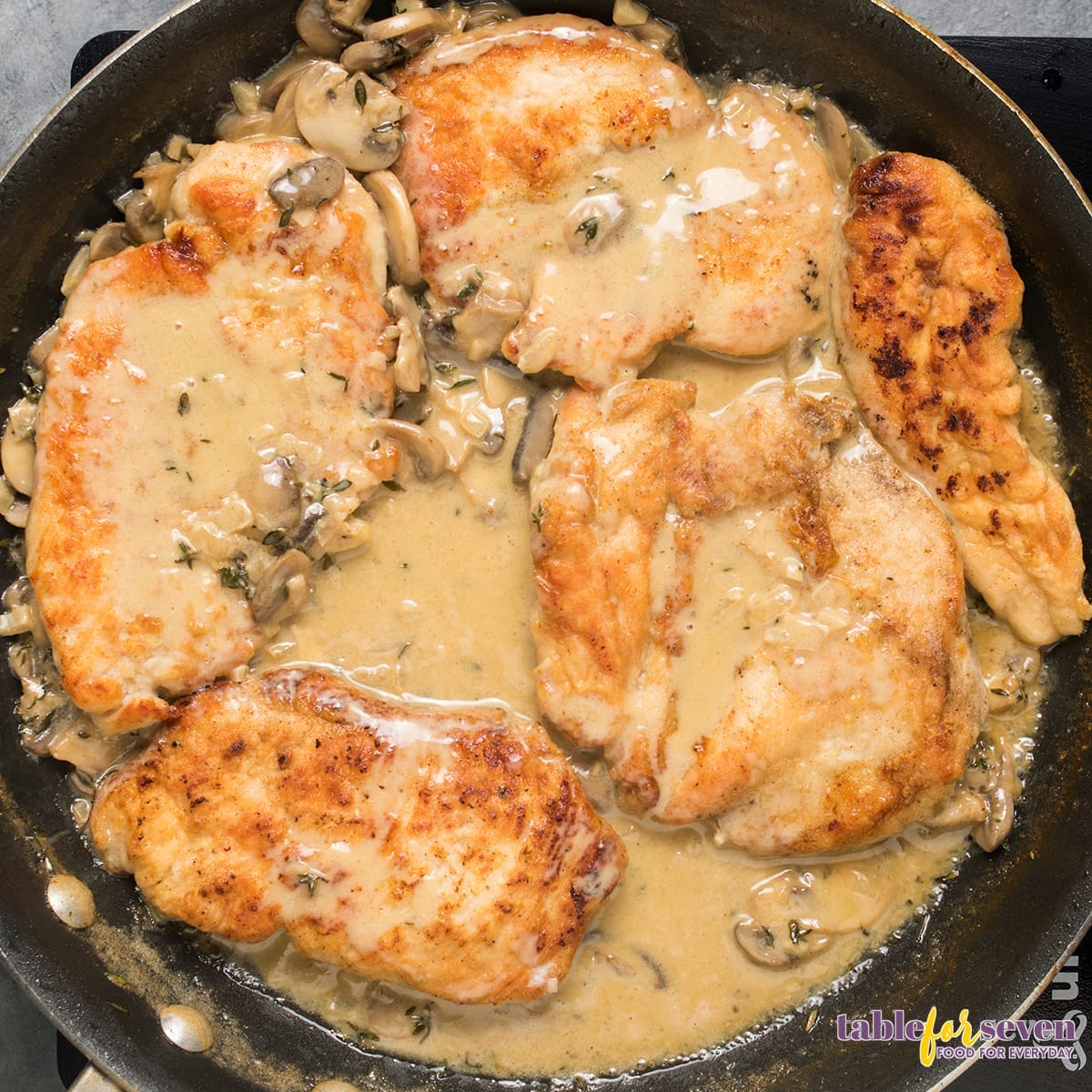 Chicken breasts cooking in creamy mushroom sauce